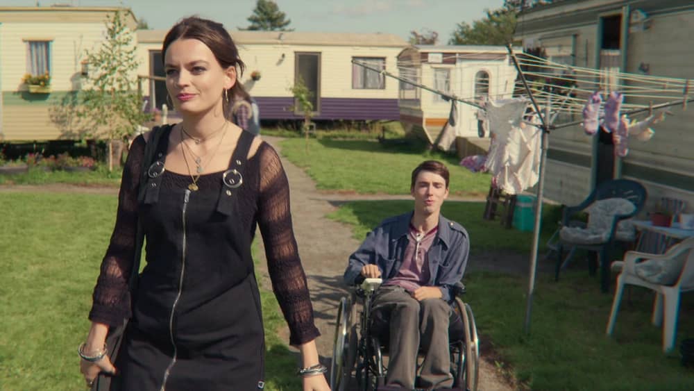 Maeve walks away from Isaac as he fellows in his wheelchair in Sex Education on Netflix.