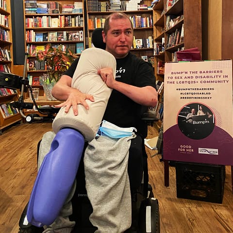 Wheelchair user Andrew Gurza holds the Bumpn Joystick sex toy for people with disabilities.